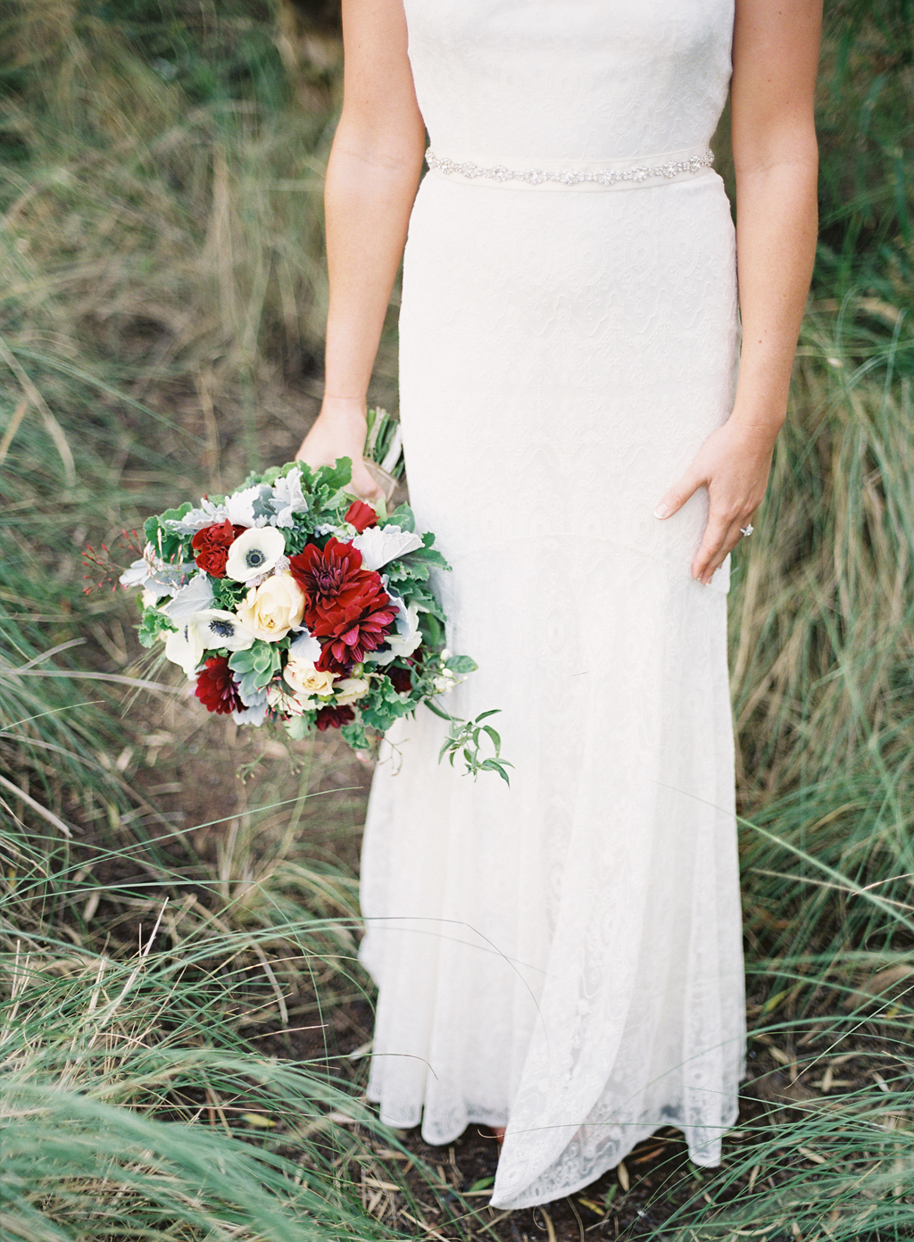 Bride standing in grass at the Estancia hotel in La Jolla with her wedding bouquet