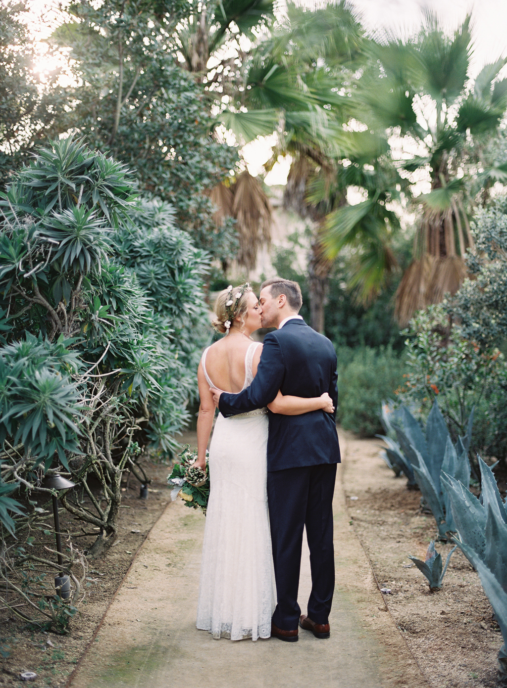 bride and groom kissing near blue agave in la jolla