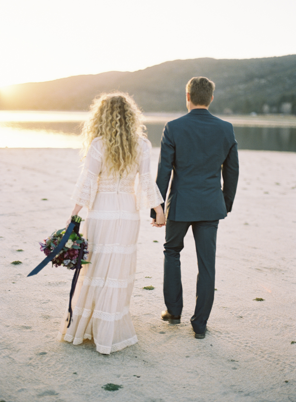 bride and groom walking near lake in Southern California.