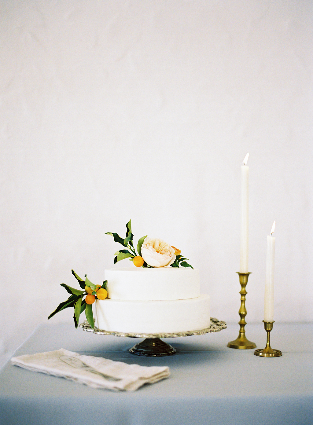 a white wedding cake by Pippa Cakery styled with flowers by ashley beyer of tinge.