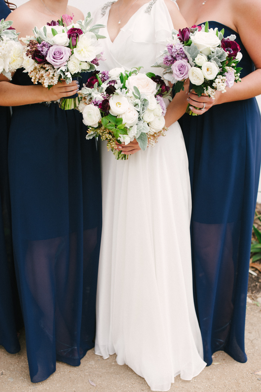 detail shot of bride and bridesmaids bouquets by art with nature and their blue dresses at a wedding in southern california