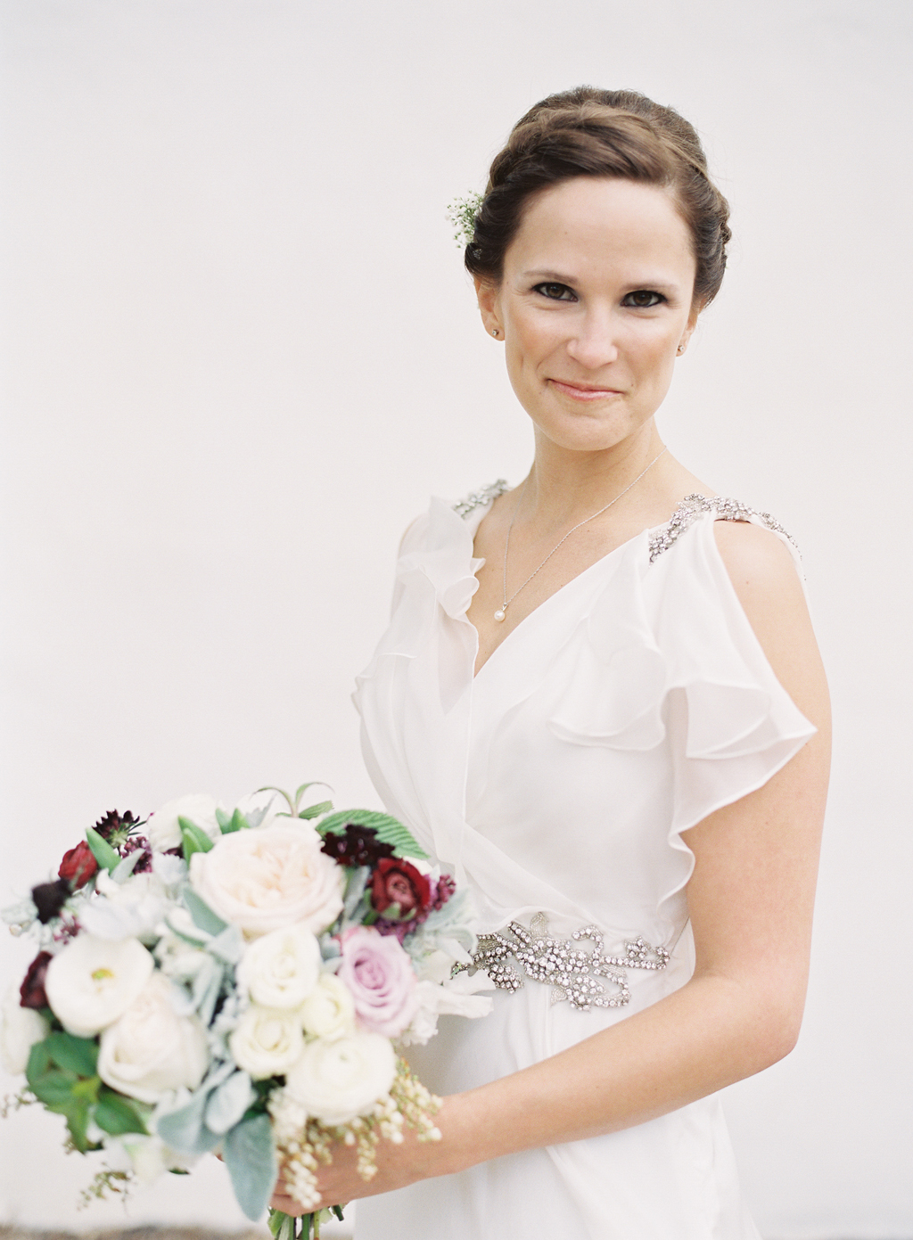 film portrait of a bride in front of a white background on her wedding day
