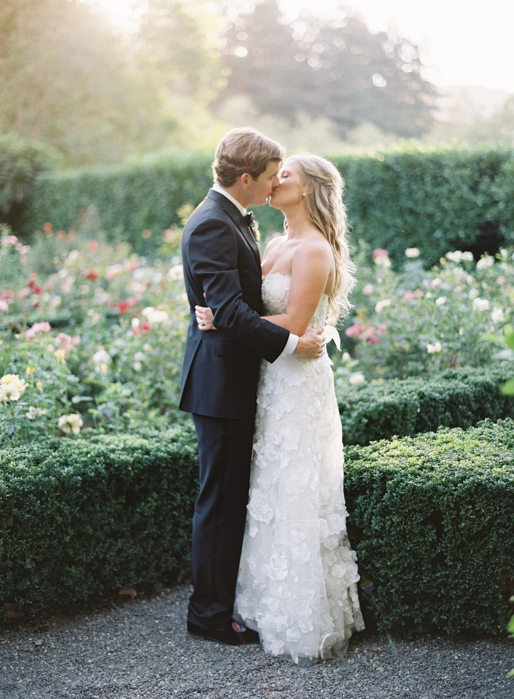 a couple poses for a kiss in the rose garden at beaulieu gardens on their wedding day film photography