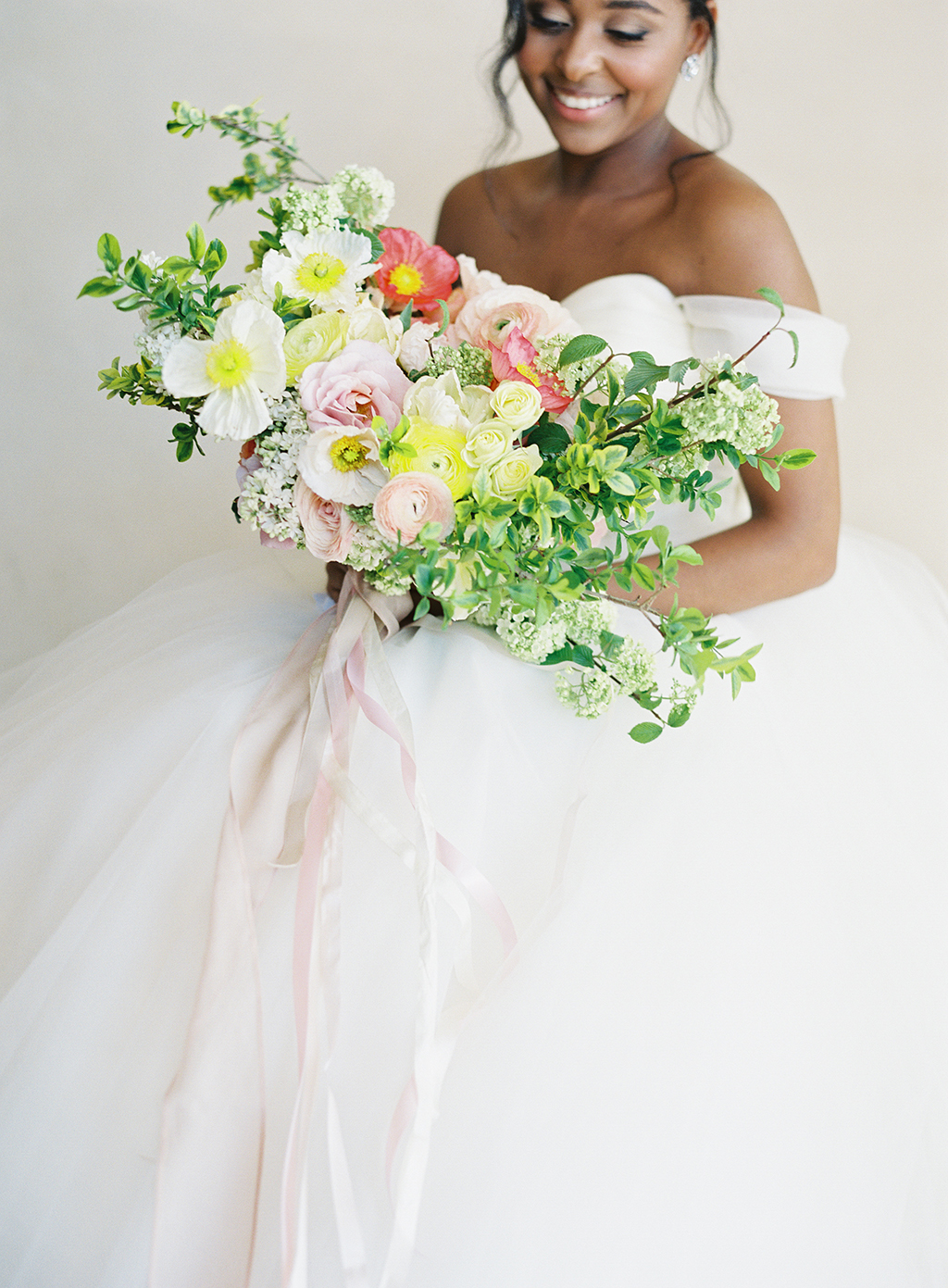 a colorful spring bouquet by art with nature and an amazing wedding gown by lazaro bridal at pelican hill resort