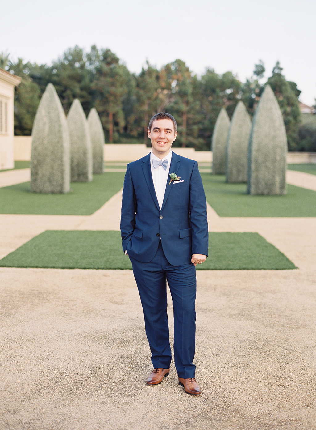 a groom standing for a film photograph at pelican hill resort in newport beach, california