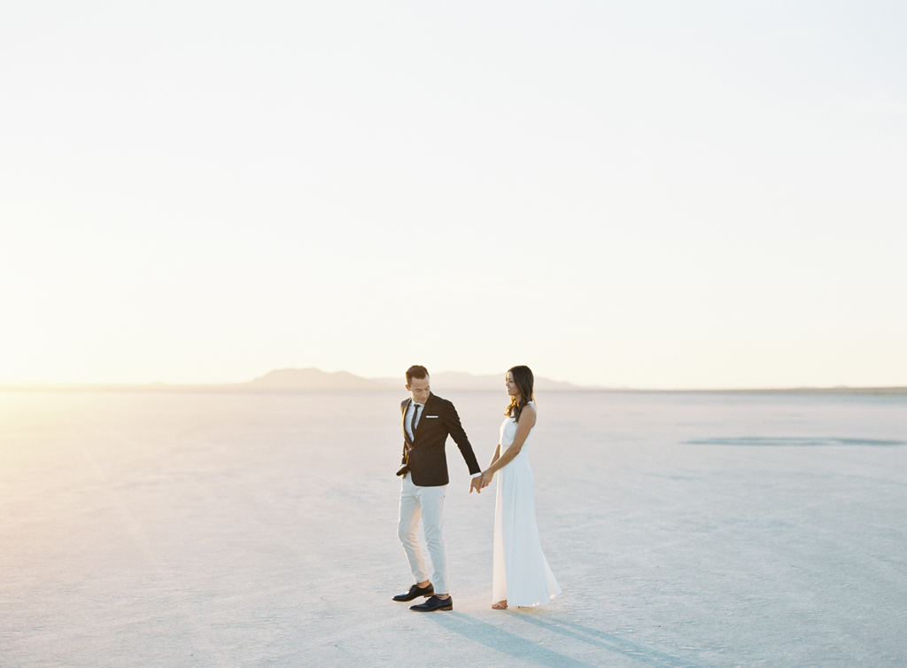 husband and wife walk through the california desert.