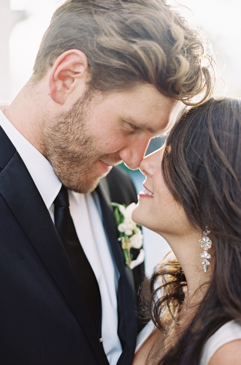 an intimate portrait of a bride and groom touching faces on their wedding day in palm springs, california.