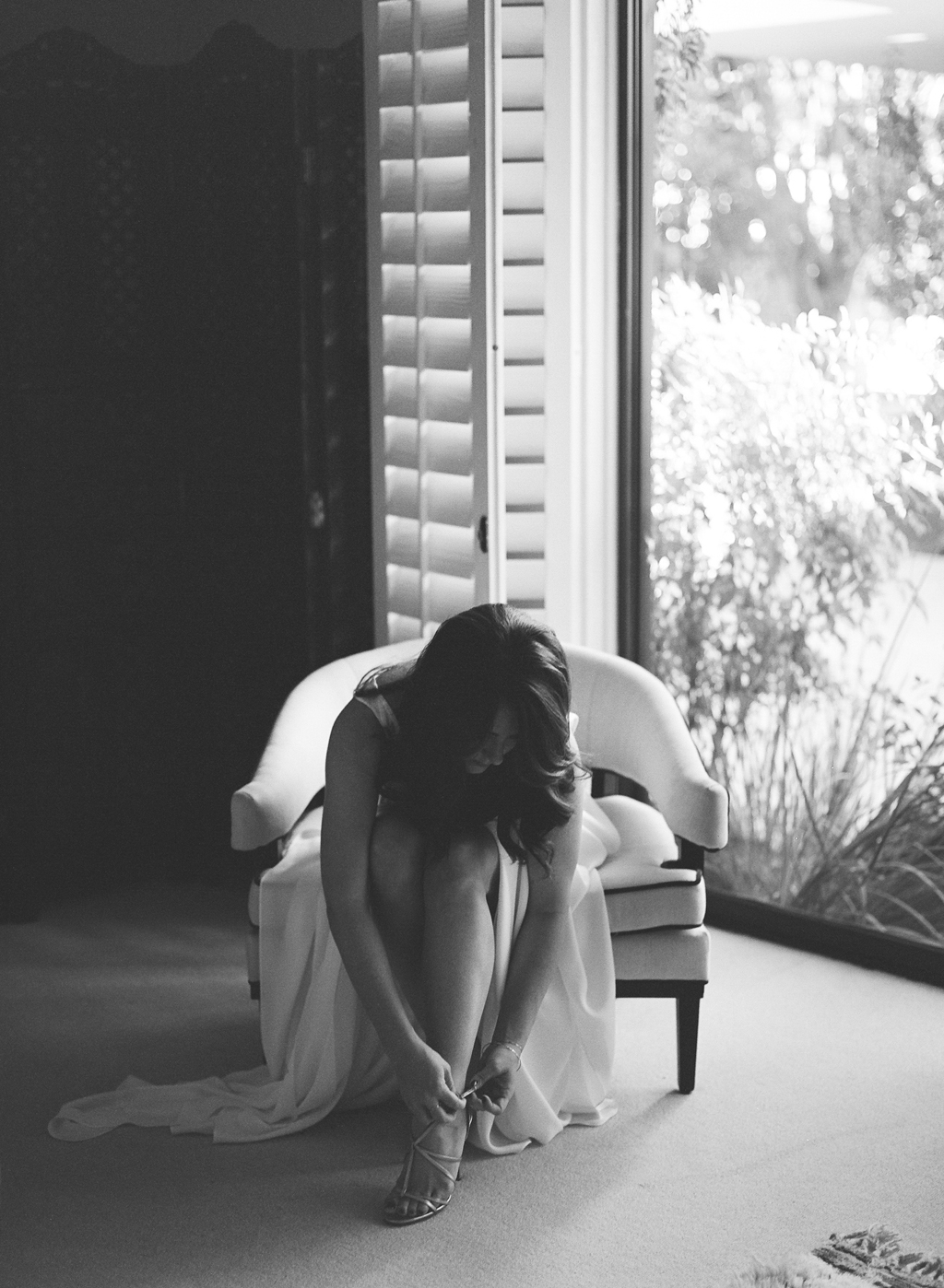 a bride in her wedding gown putting on her shoe before her wedding ceremony in palm springs. 