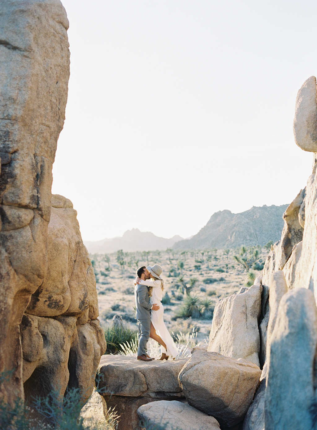 a couple poses for their engagement session in joshua tree california.